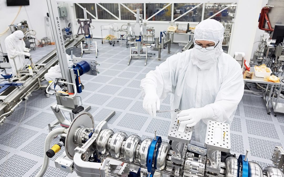 Technician working with semiconductor-related equipment in a cleanroom