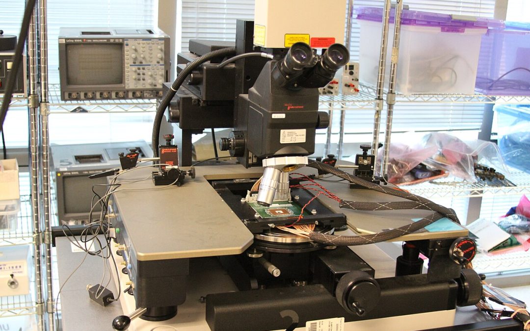 Close view of a semiconductor chip testing workstation with a microscope and test equipment, photograph by Lenore Edman (CC BY 2.0)