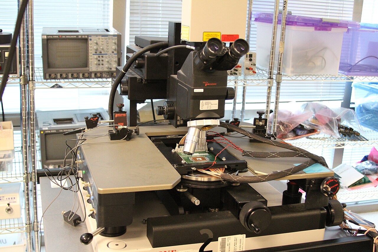 Semiconductor chip testing workstation with microscope and electronics, photograph by Lenore Edman (CC BY 2.0)