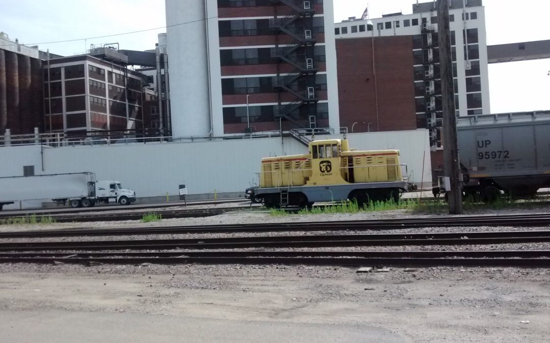 Historic 2015 exterior photograph of the Quaker Oats plant in Cedar Rapids, Iowa, with a yellow rail locomotive; not footage of the 24 October 2026 fire