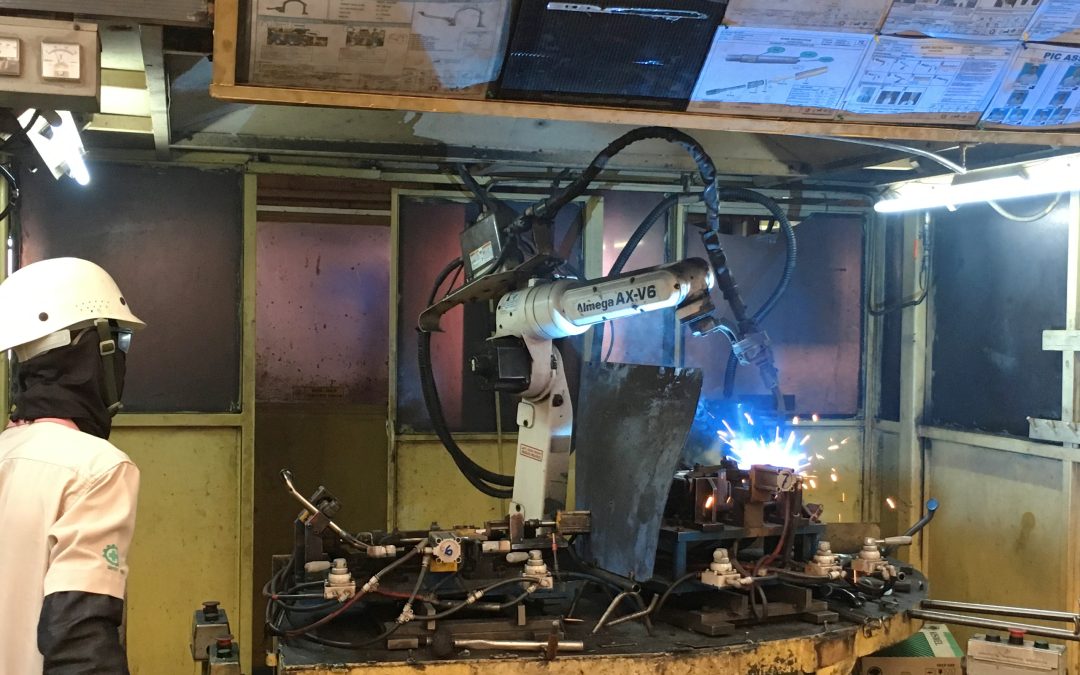 Industrial welding robots operating in an automated manufacturing facility