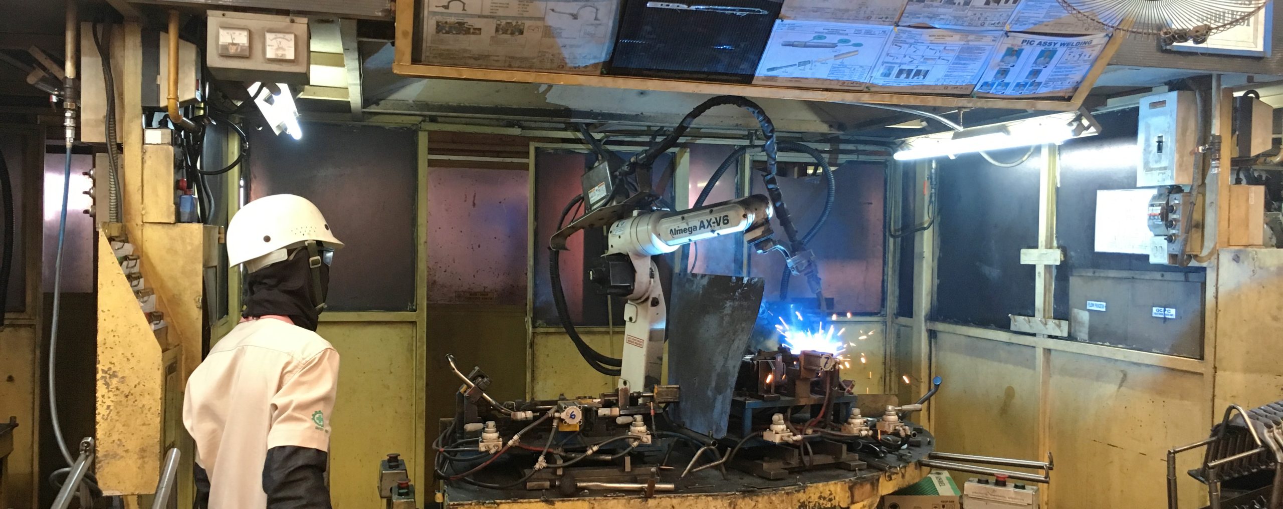 Industrial welding robots operating in an automated manufacturing facility