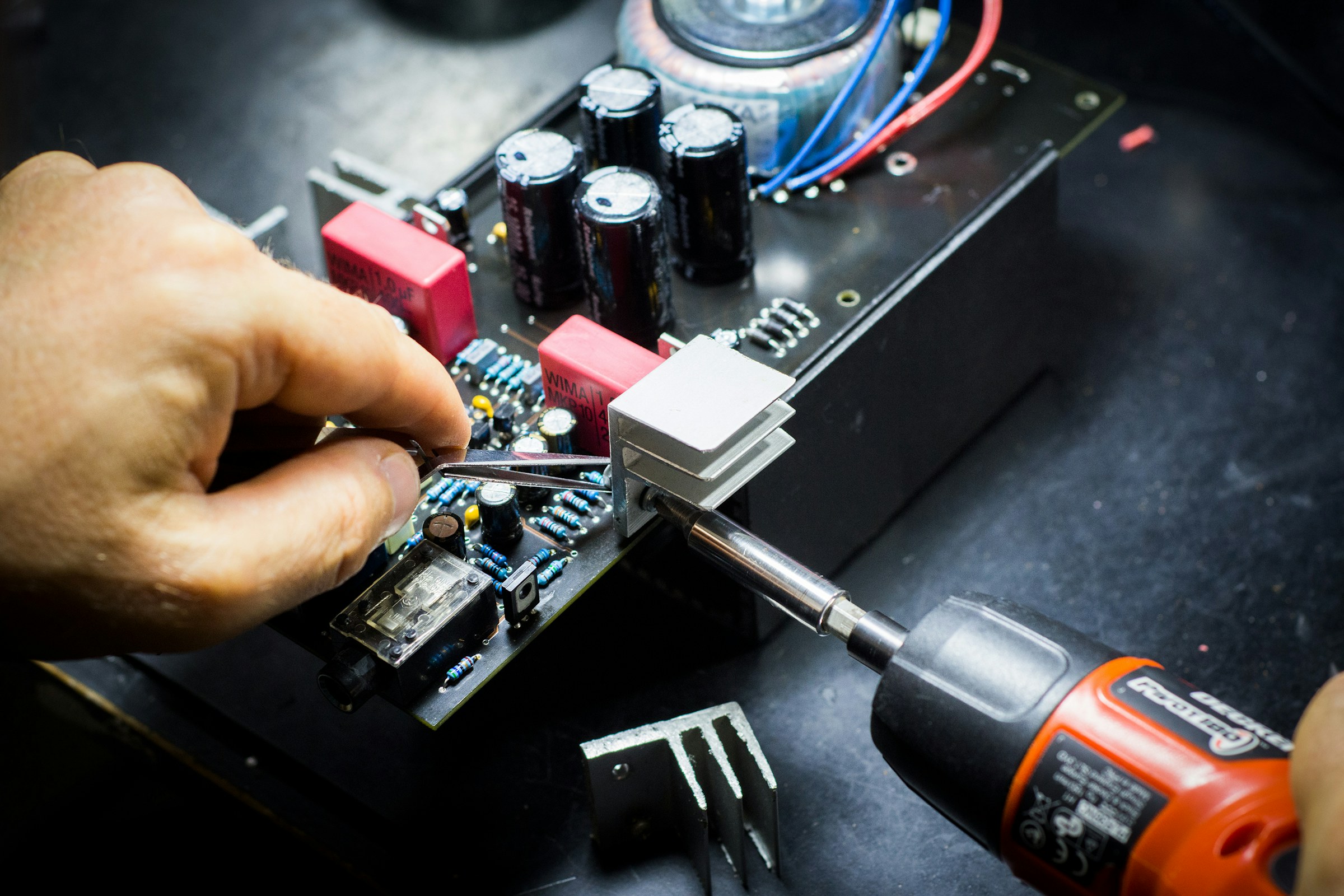 Technician working on a printed circuit board during manual electronics assembly